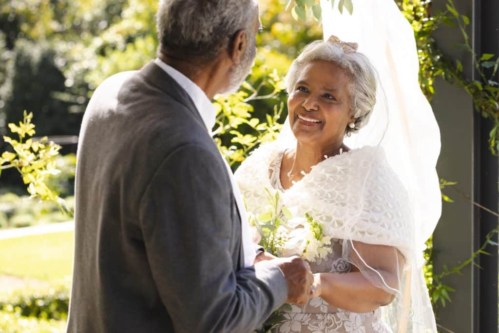 An elderly couple exchanging vows outdoors